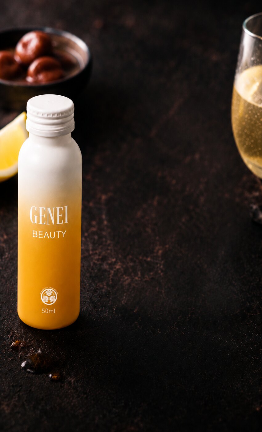 梅とレモン、スパークリングのグラスと並ぶGENEI BEAUTYボトル
